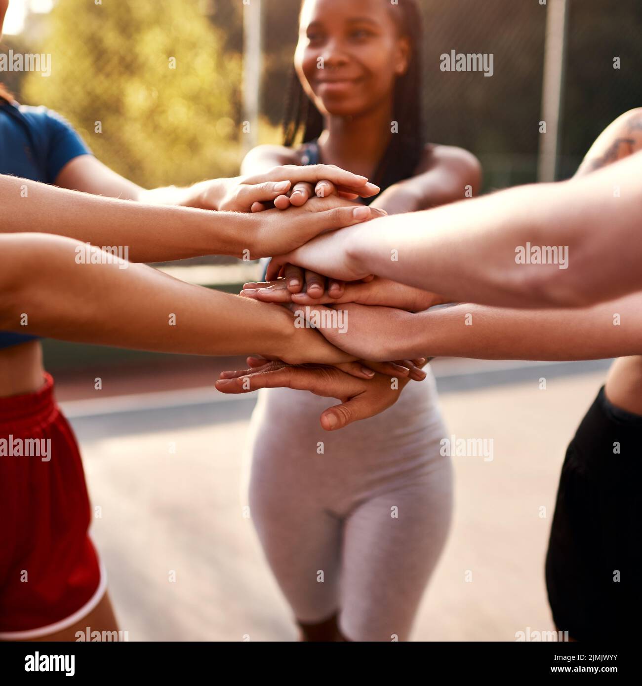 Were ready to win. an unrecognizable group of sportswomen piling their hands together before a basketball game. Stock Photo