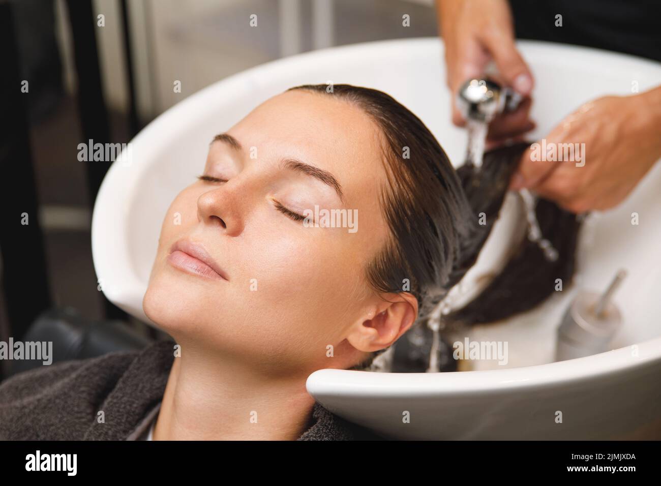 Woman in hairdresser salon during hair wash after haircut Stock Photo