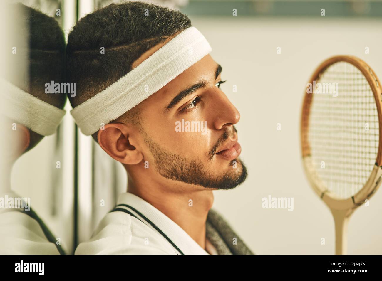 A game of physical and mental skill. a young man looking thoughtful in the locker room after a game of squash. Stock Photo