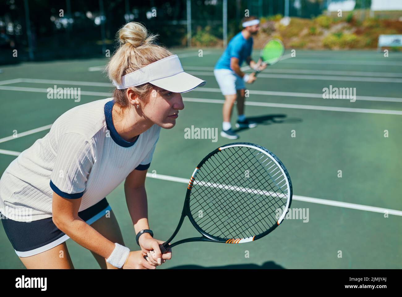 Winners never lose their focus. an attractive young female tennis player playing together with a male teammate outdoors on a court. Stock Photo