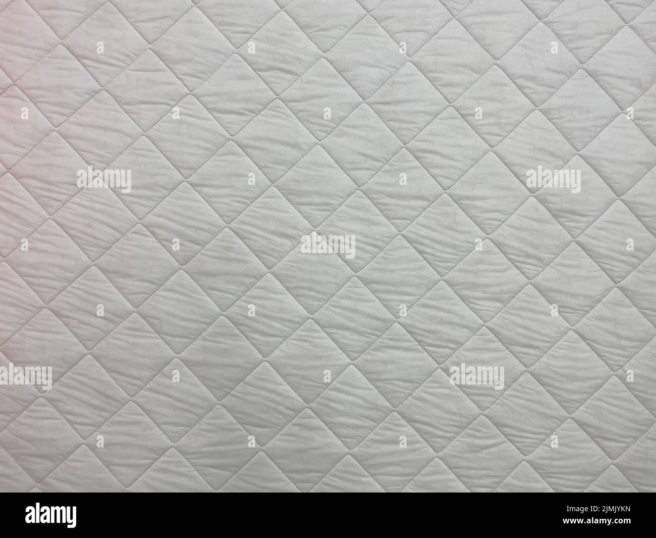 White blanket texture close-up. Blanket texture. Patchwork quilt pattern. White background of square shape. Stock Photo
