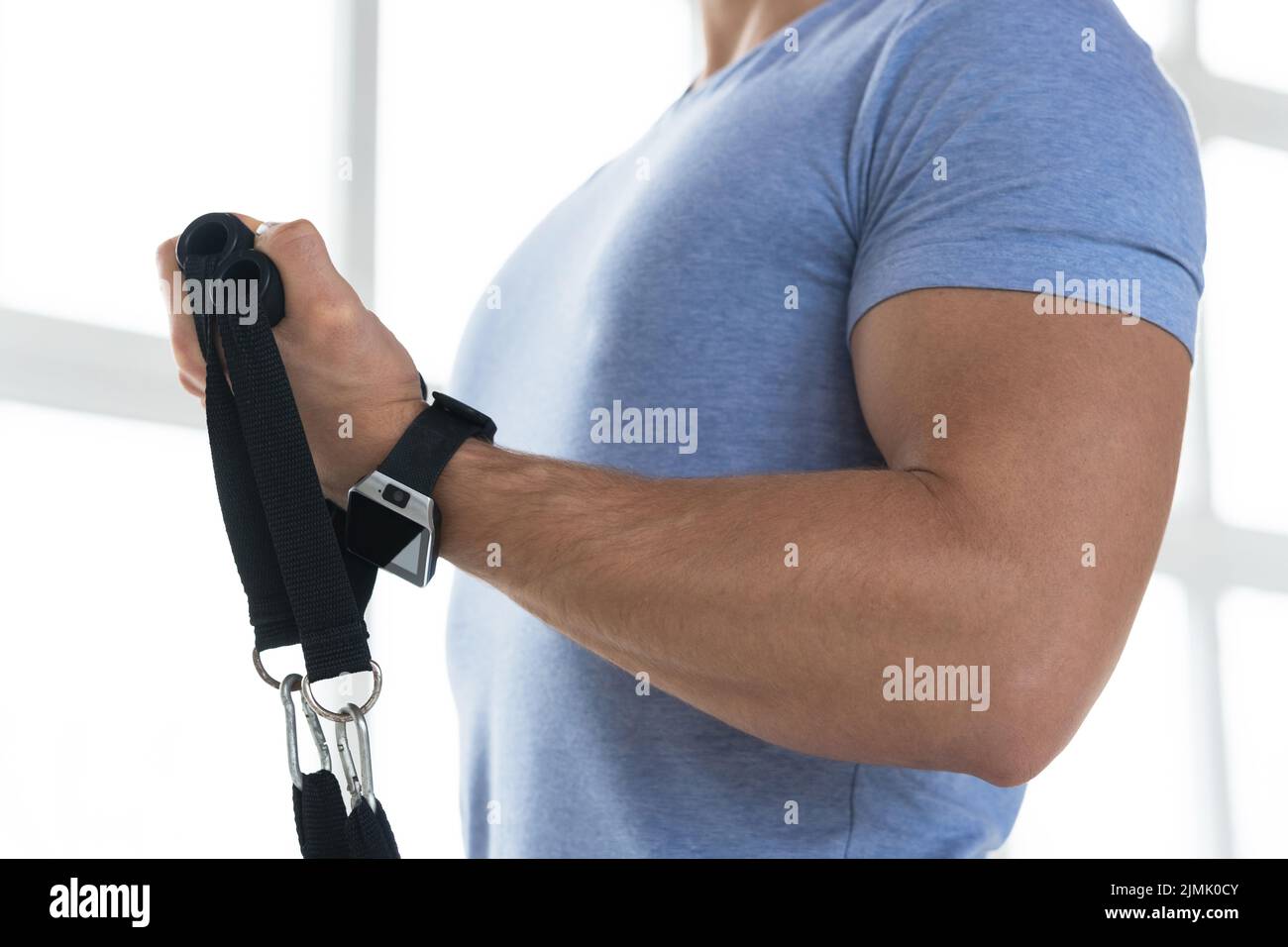Young man during workout with a resistance bands in the gym Stock Photo