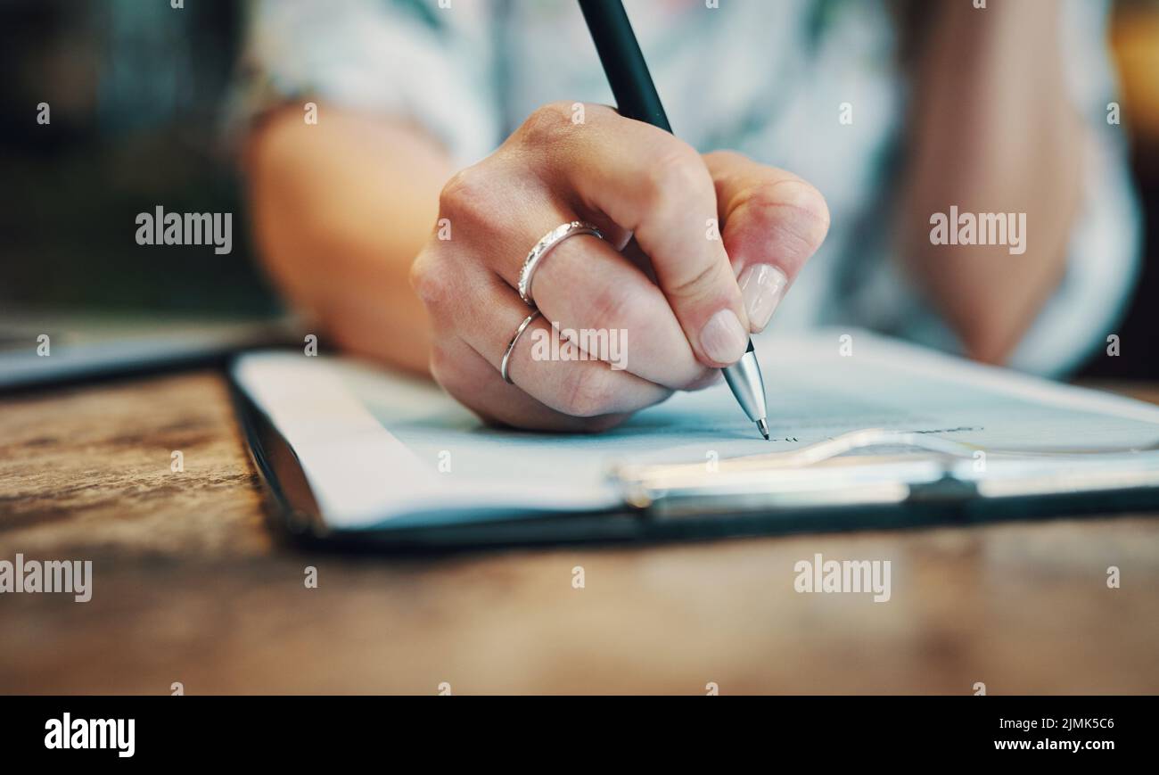 Filling in the paperwork. an unrecognizable businesswoman sitting alone ...
