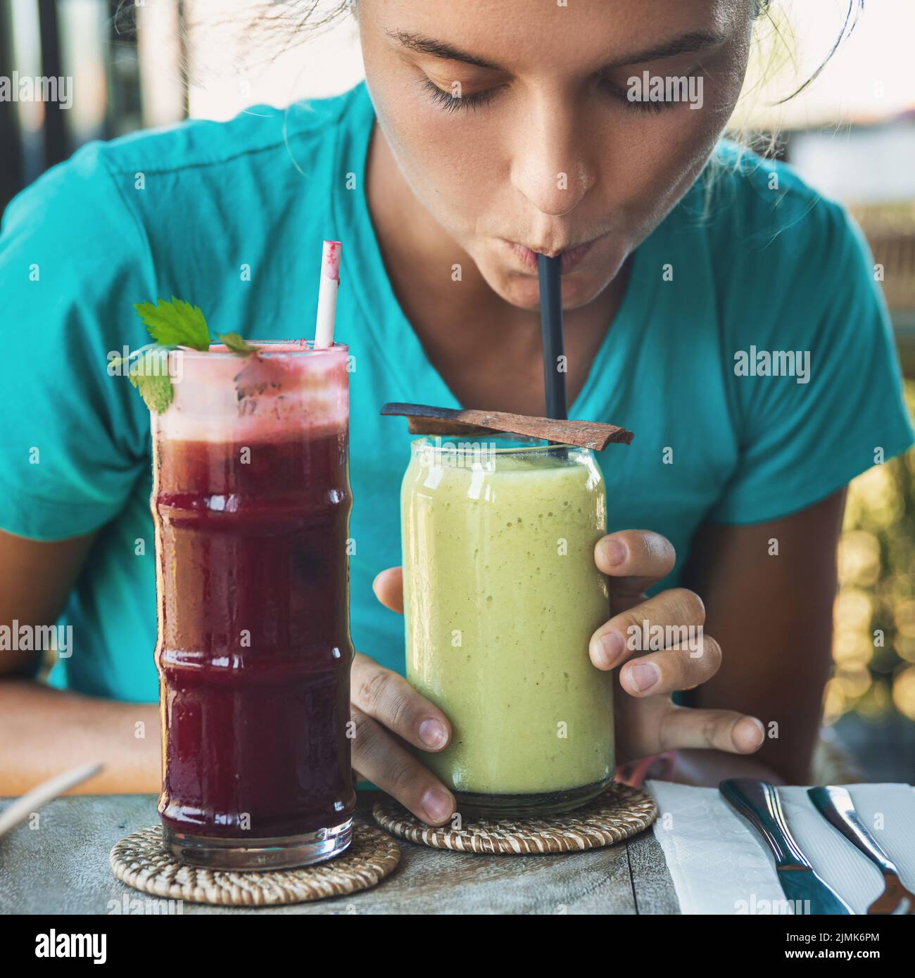 Woman is tasting different healthy drinks in vegan cafe Stock Photo