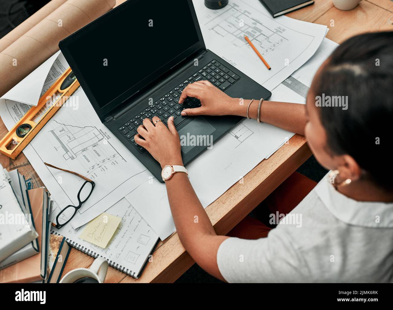 Making progress on all her tasks. High angle shot of an architect ...