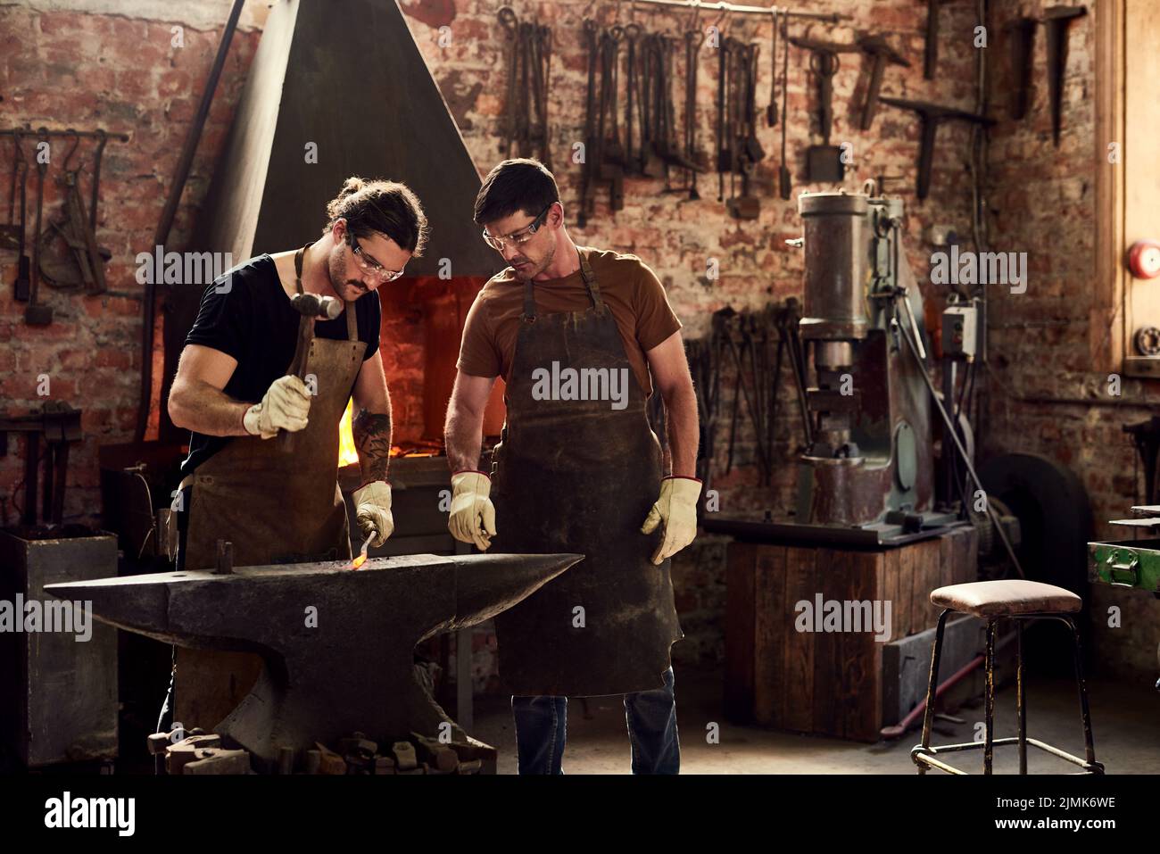 Were the heavy metal guys. two handsome young metal workers working together inside a welding workshop. Stock Photo