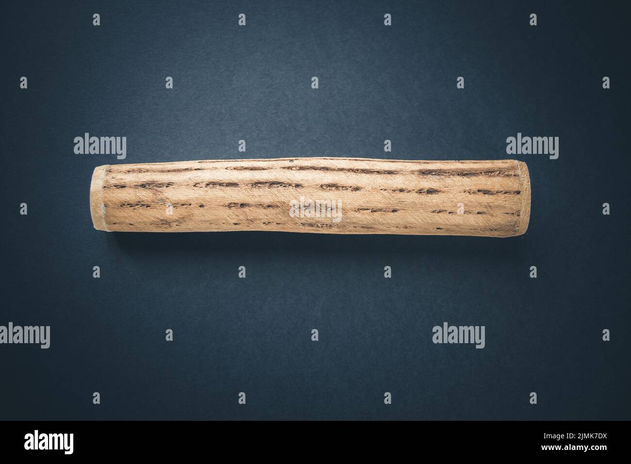 Traditional rain stick made of cactus wood isolated on black Stock