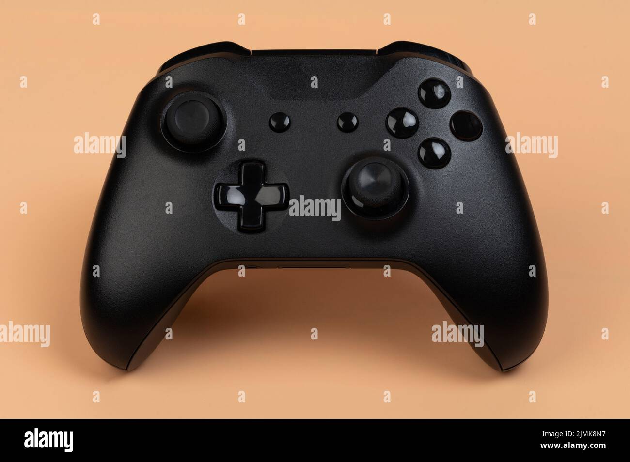 Black game controller front view isolated on brown background Stock Photo