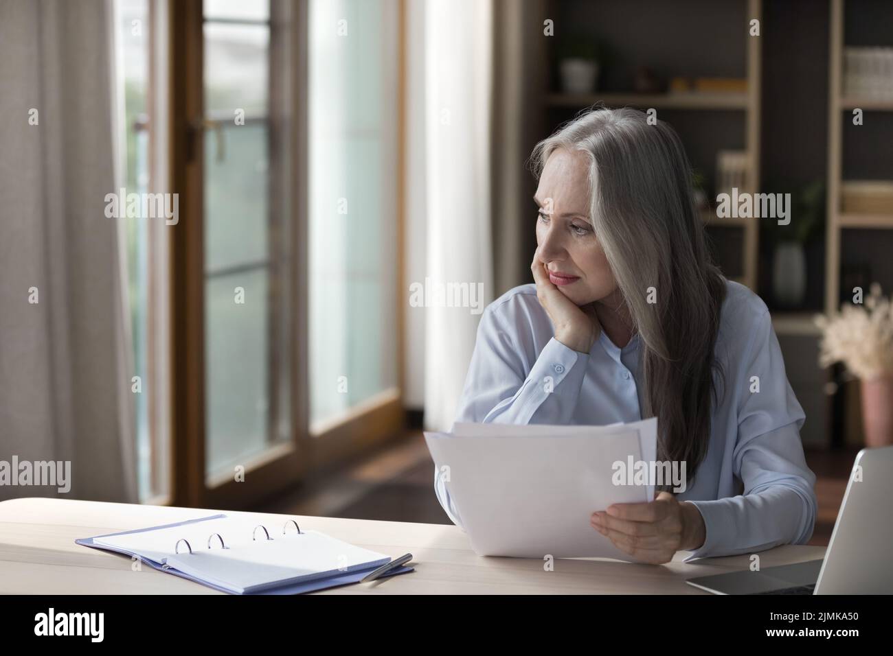 Mature woman paperwork thinking hi-res stock photography and images - Alamy