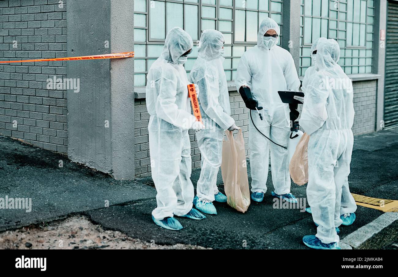 What the world looks like today. a group of healthcare workers wearing hazmat suits working together during an outbreak in the city. Stock Photo