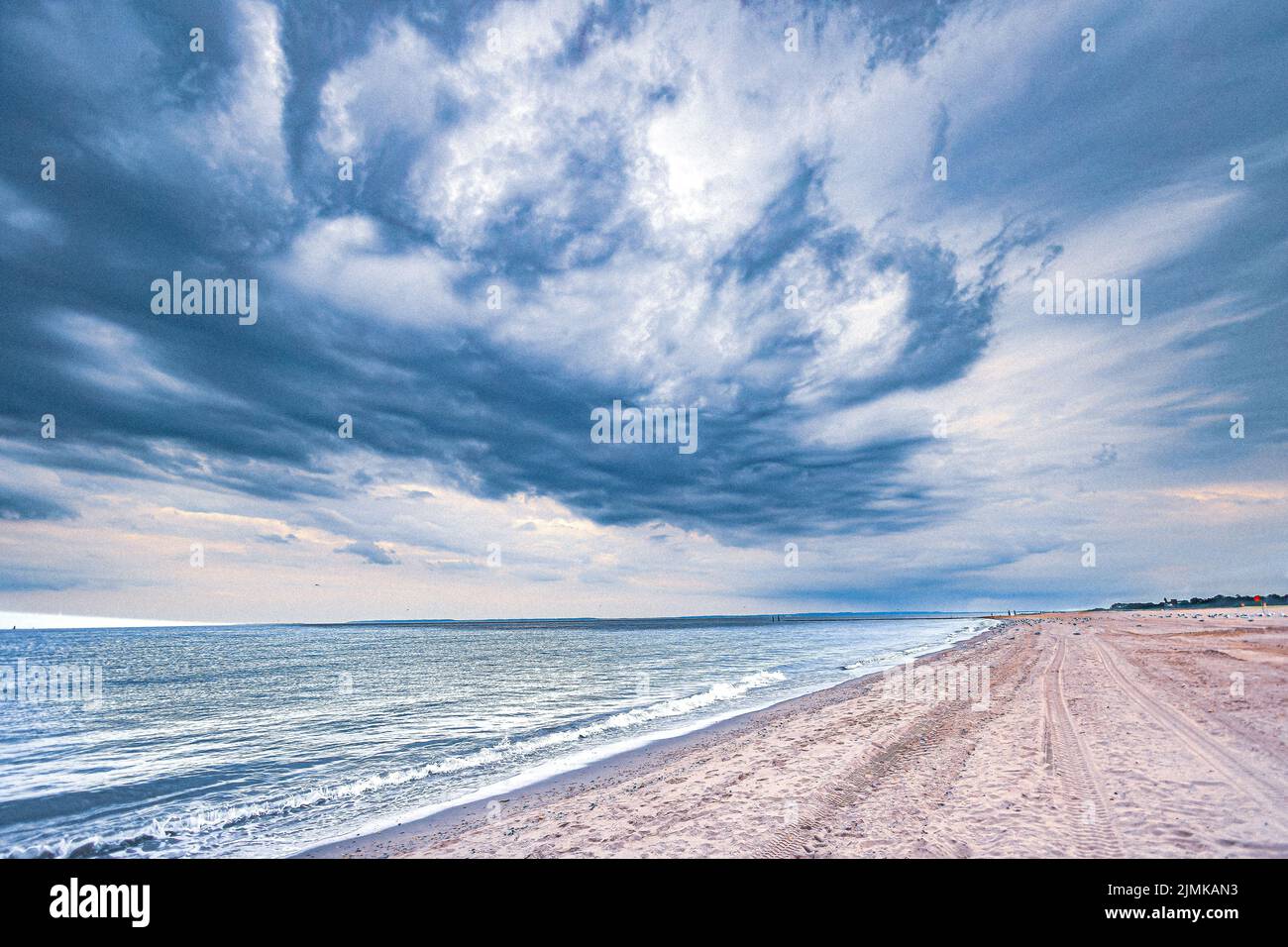 A View Of A Deserted Sandy Beach With Lovely Blue Cloud Patterns Above a-view-of-a-deserted-sandy-beach-with-lovely-blue-cloud-patterns-above