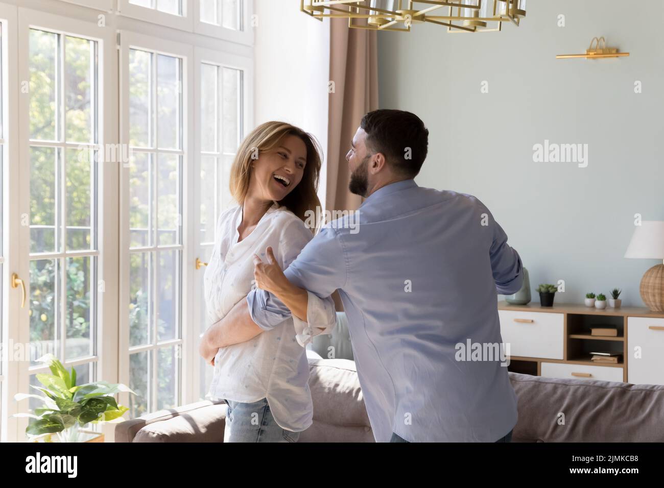 Untroubled couple in love dance together at modern home Stock Photo