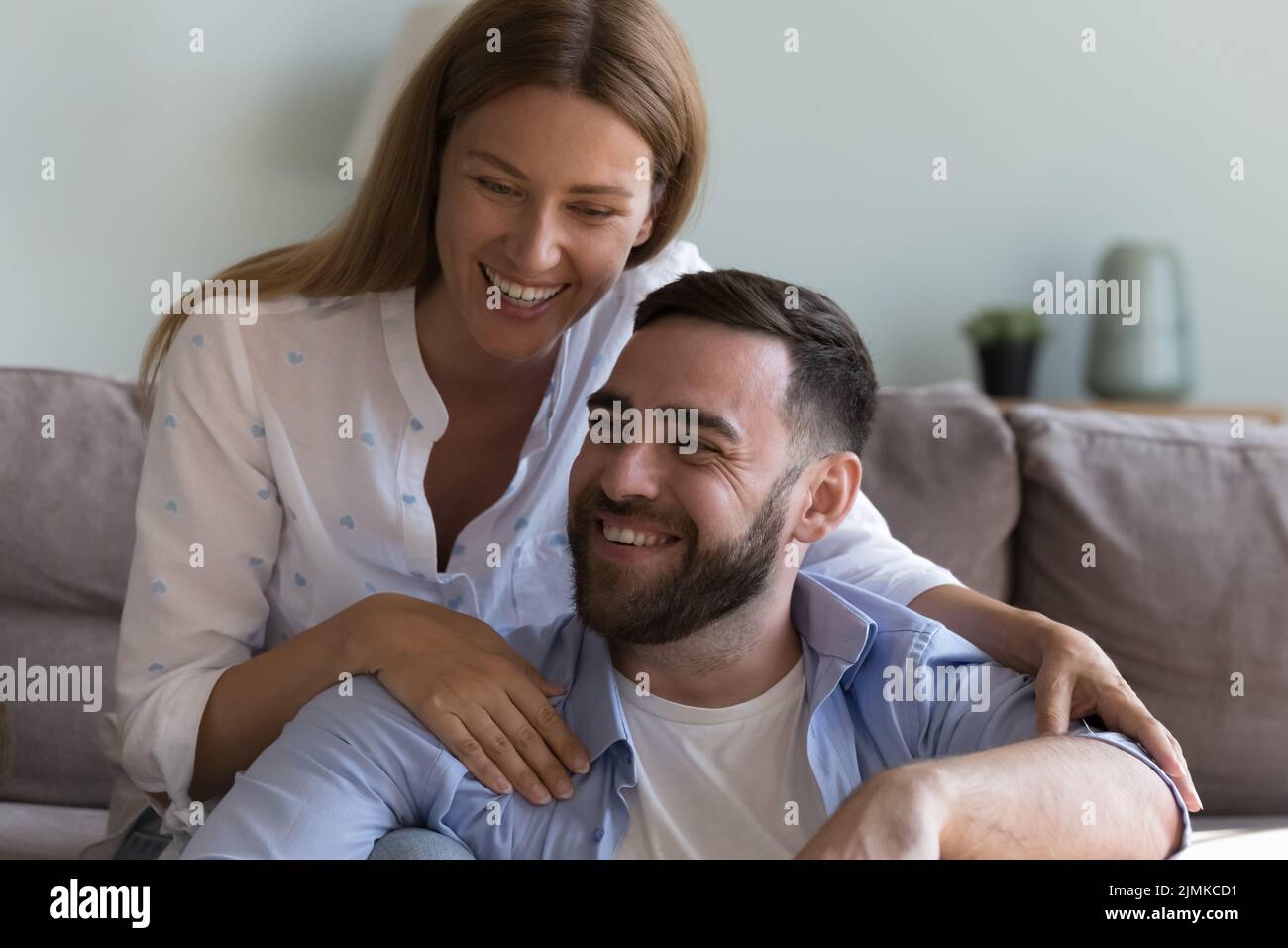 Close up cheerful couple hugging laughing at home Stock Photo - Alamy