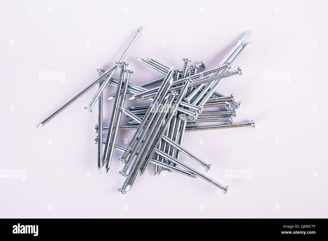 Construction nails in a pile on a white background. Stock Photo