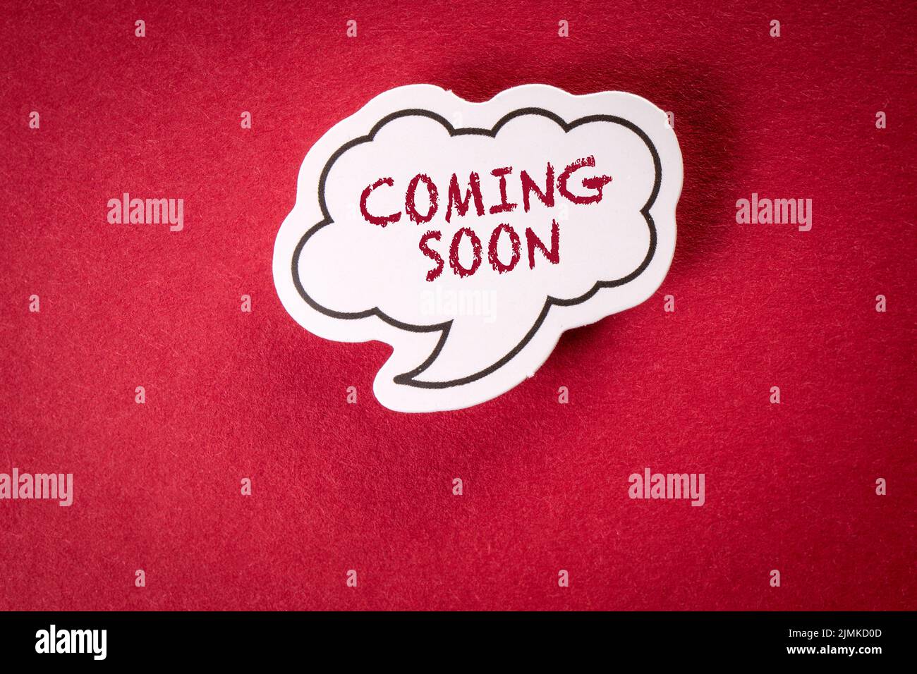 Coming Soon. White speech bubble on red background. Stock Photo