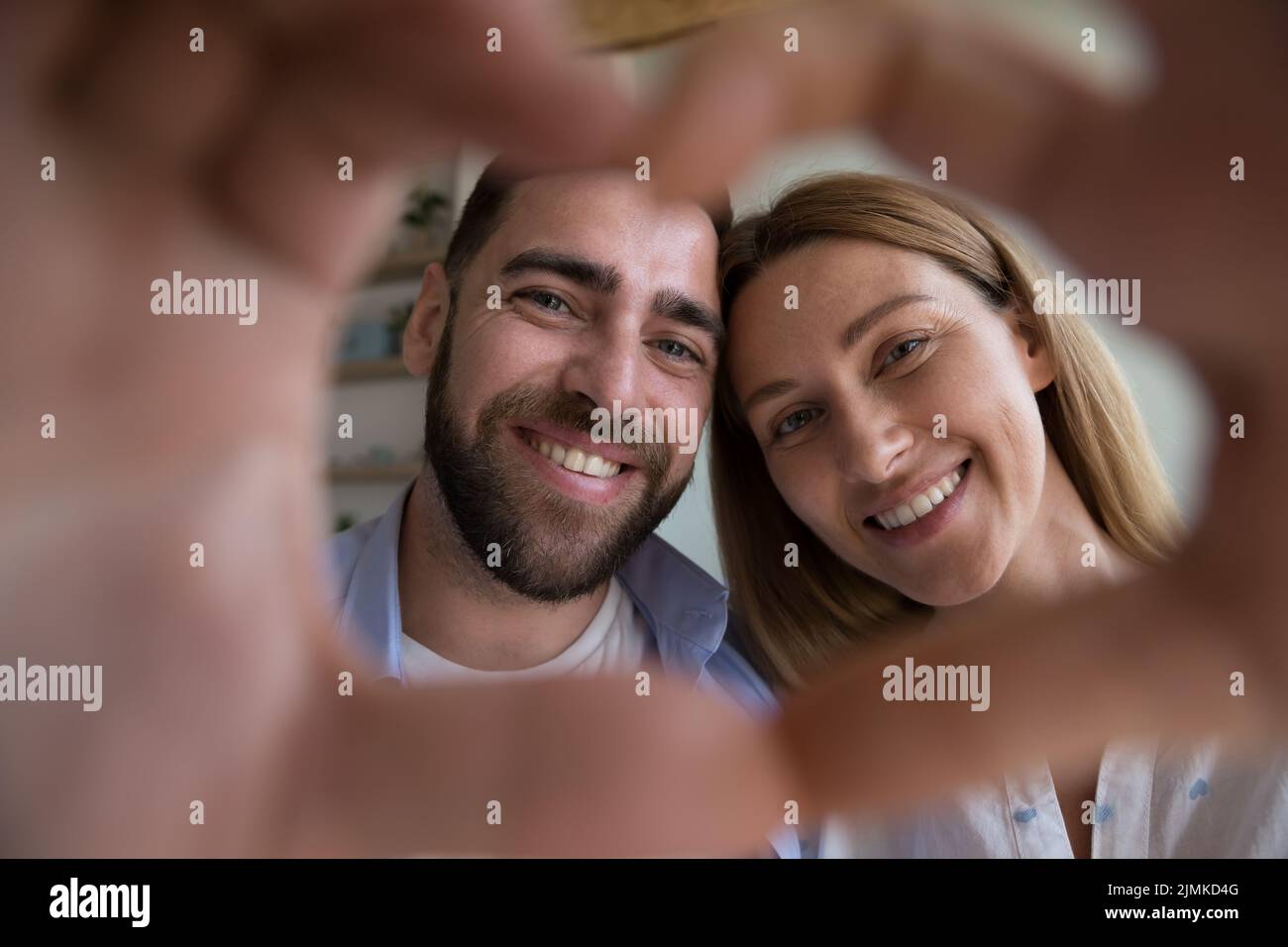 Beautiful couple showing heart shape to camera, close up shot Stock Photo