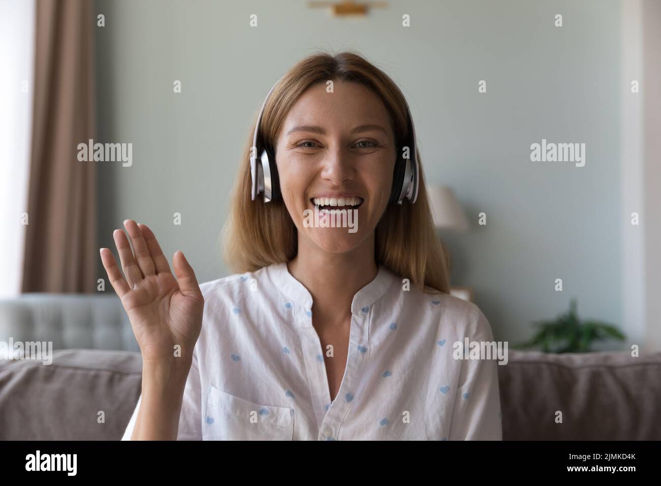 Pretty woman wear headphones greeting friend start video conference Stock Photo