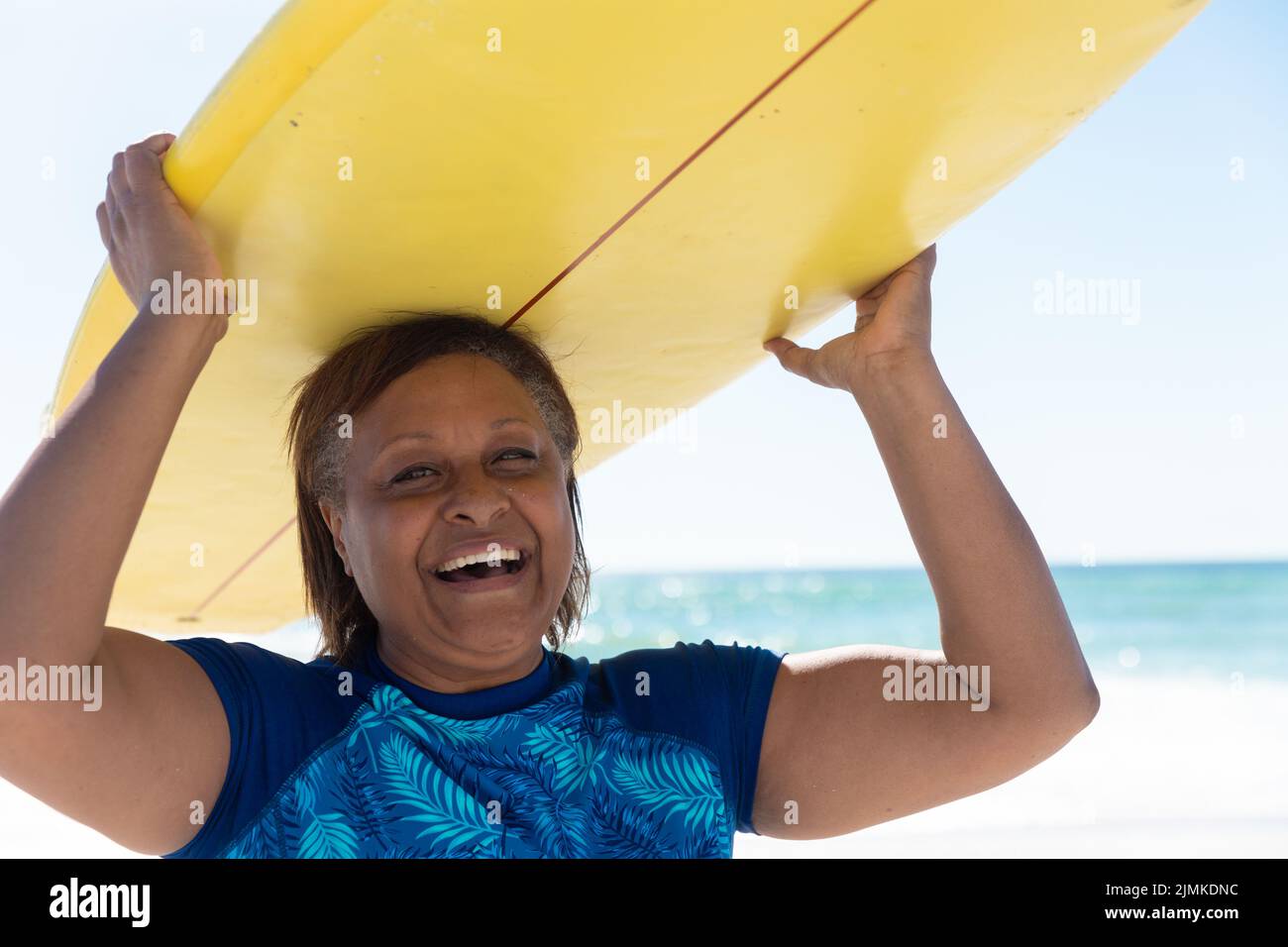 Portrait of happy retired african american senior woman carrying yellow ...