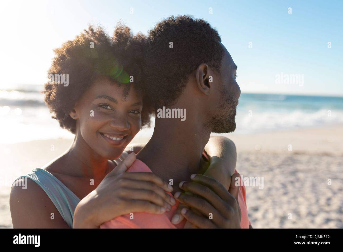 Portrait of smiling african american woman hugging boyfriend from ...