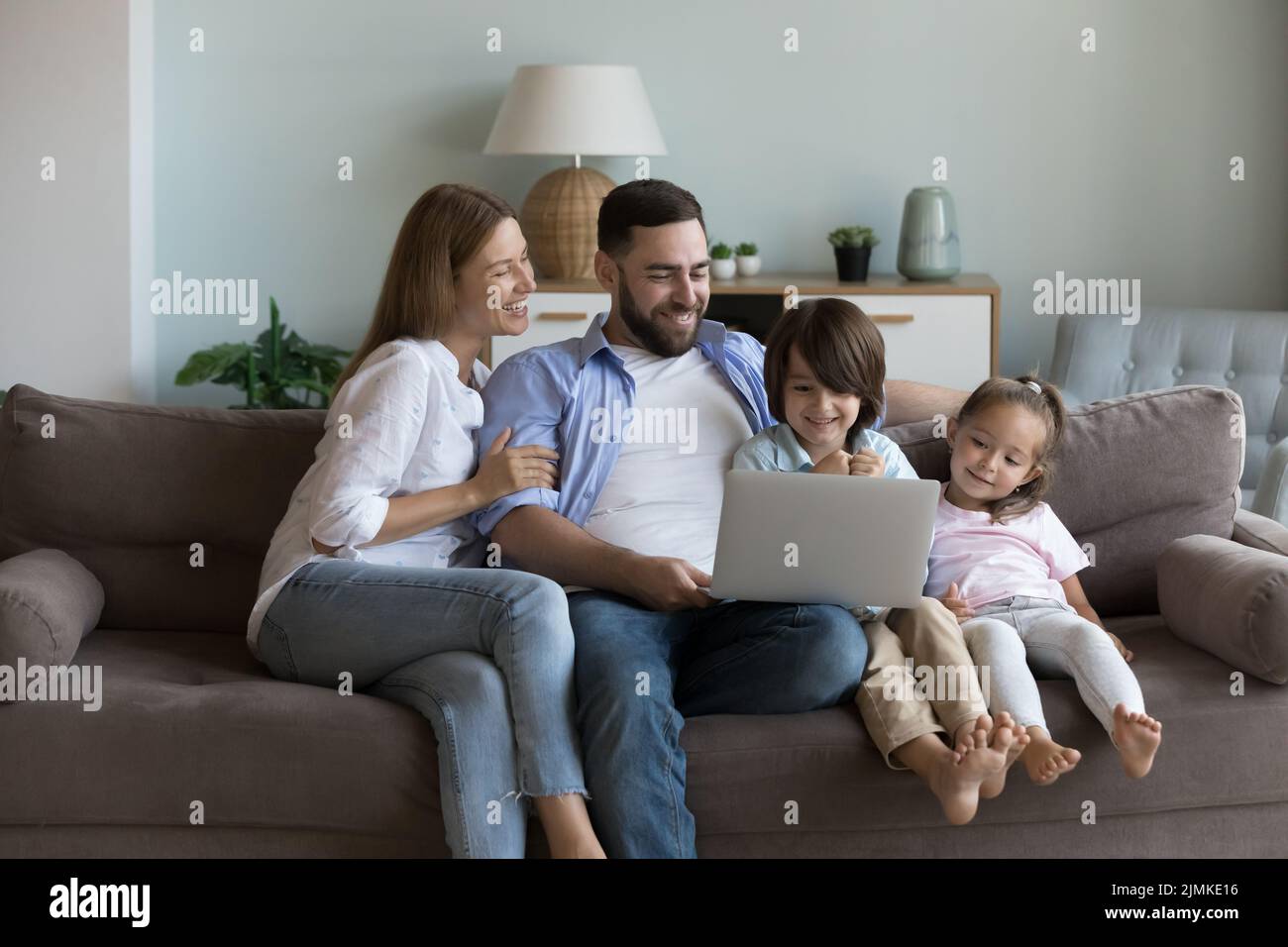 Couple and siblings spend leisure on internet using computer Stock Photo