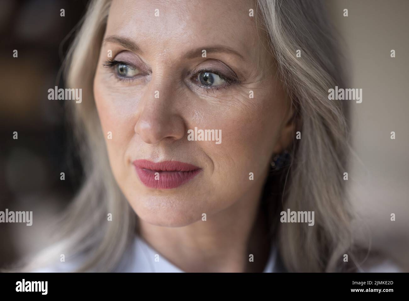 Pensive dreamy middle aged senior woman face close up Stock Photo