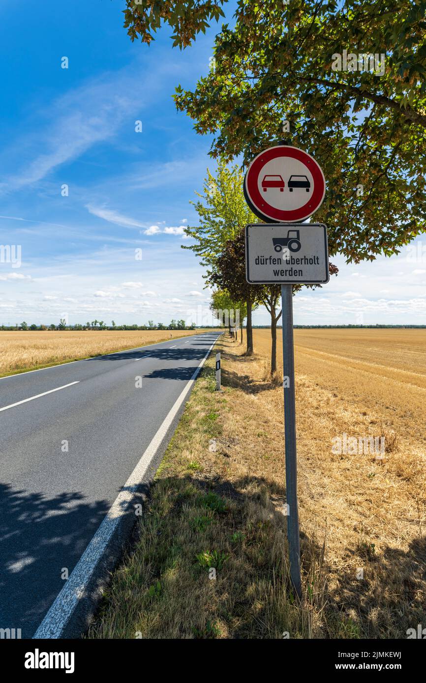 Traffic sign no overtaking with the additional sign tractors may be overtaken in German language Stock Photo