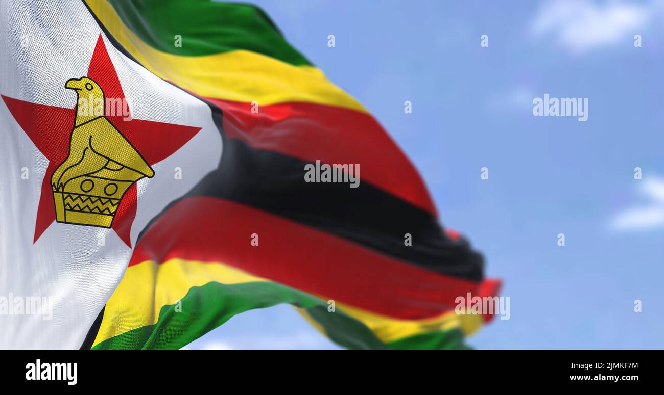 Detail of the national flag of Zimbabwe waving in the wind on a clear ...