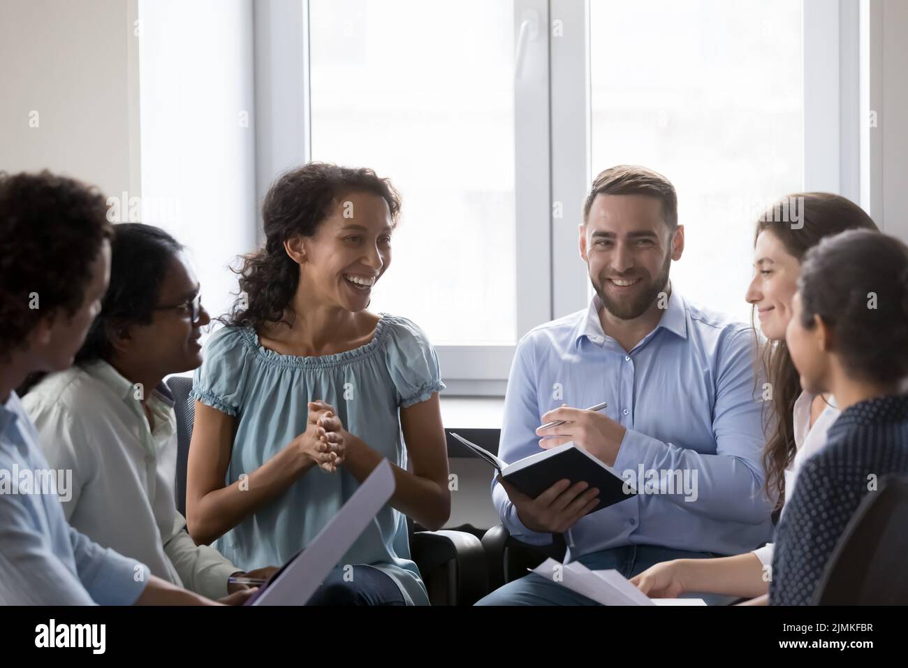 Smiling multiracial colleagues take part in motivational training at workplace Stock Photo