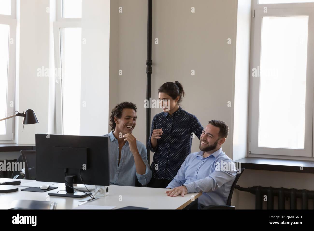 Happy positive multi ethnic colleagues joking laughing during break Stock Photo