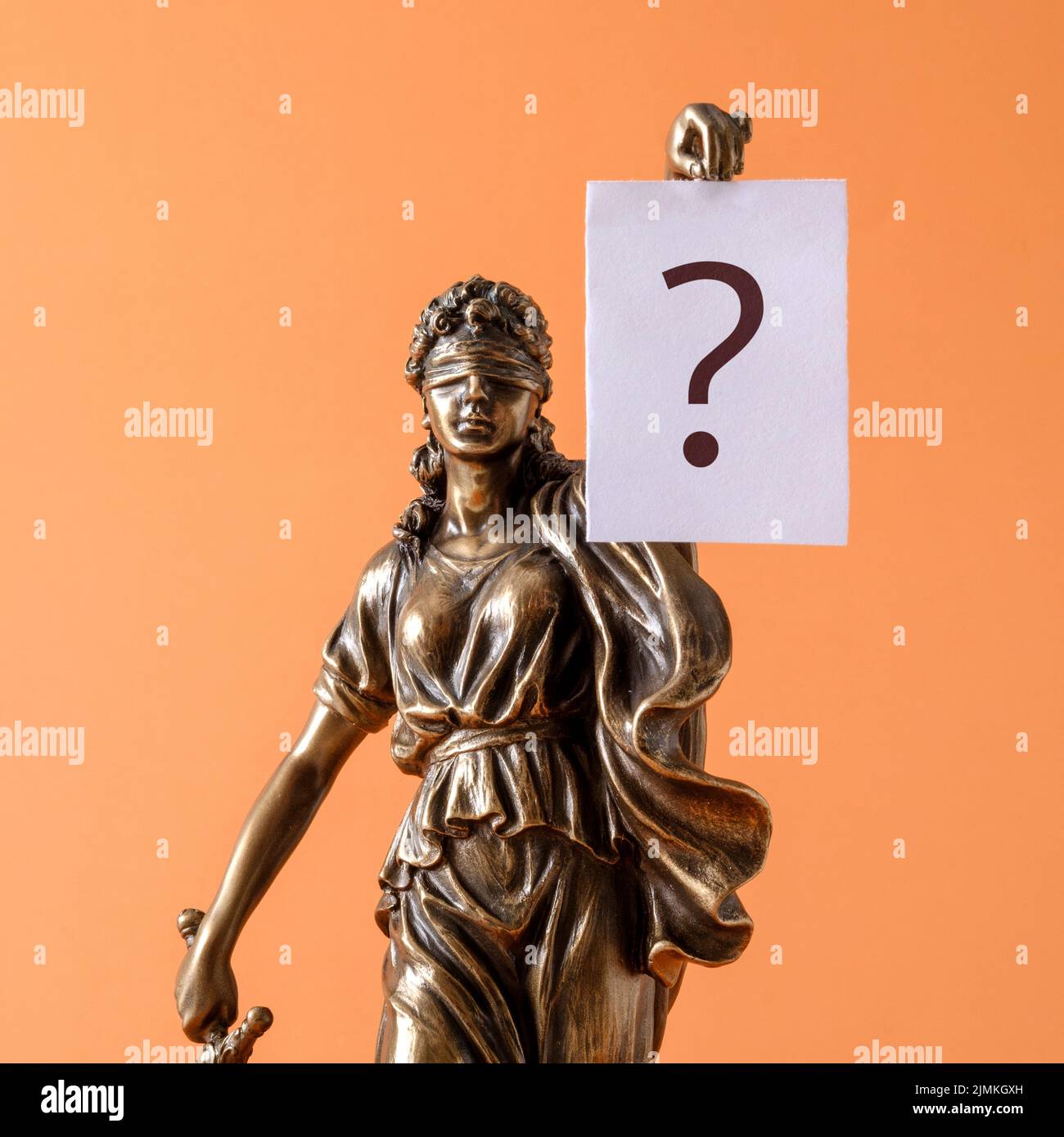 Statue of justice Themis is a symbol of law and freedom and a white sheet of paper banner with a question mark. Minimal creative concept. Stock Photo