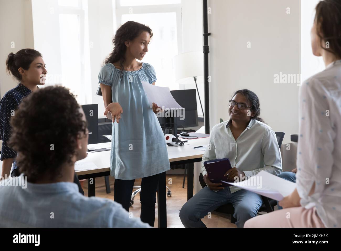 African female business coach lead meeting with group of employees Stock Photo