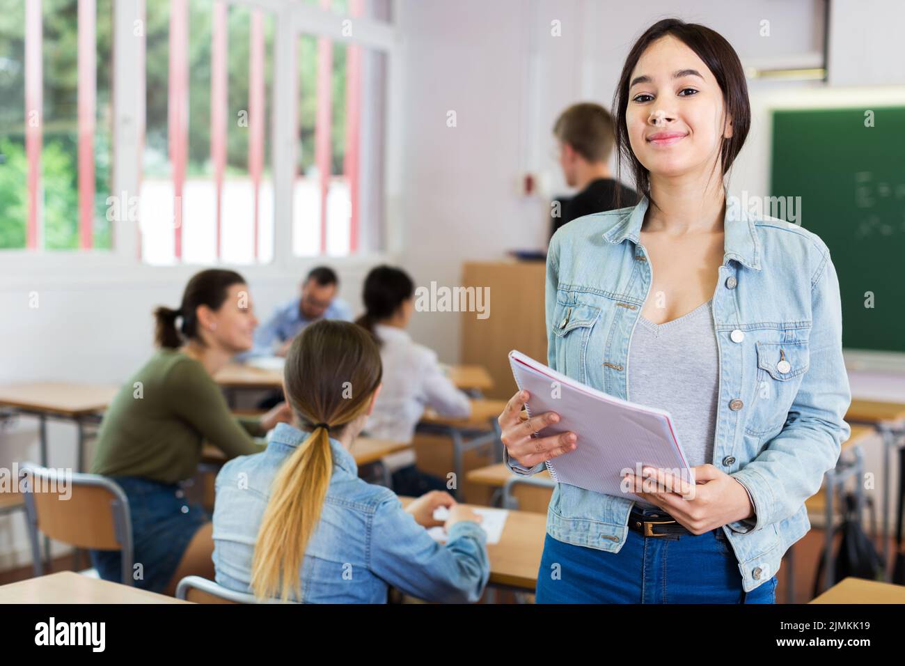Smiling schoolgirl in classroom Stock Photo - Alamy