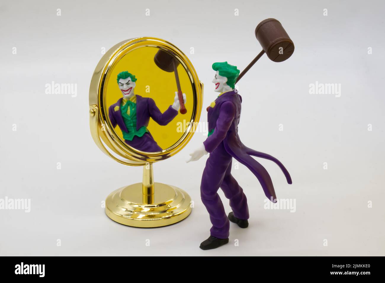 The Joker miniature looks at himself in the mirror. Joker from DC comics. Stock Photo