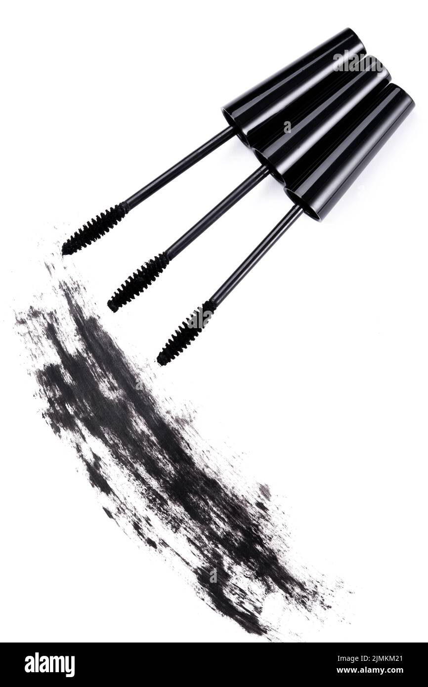 Brushes wands and smudged mascara on white background Stock Photo
