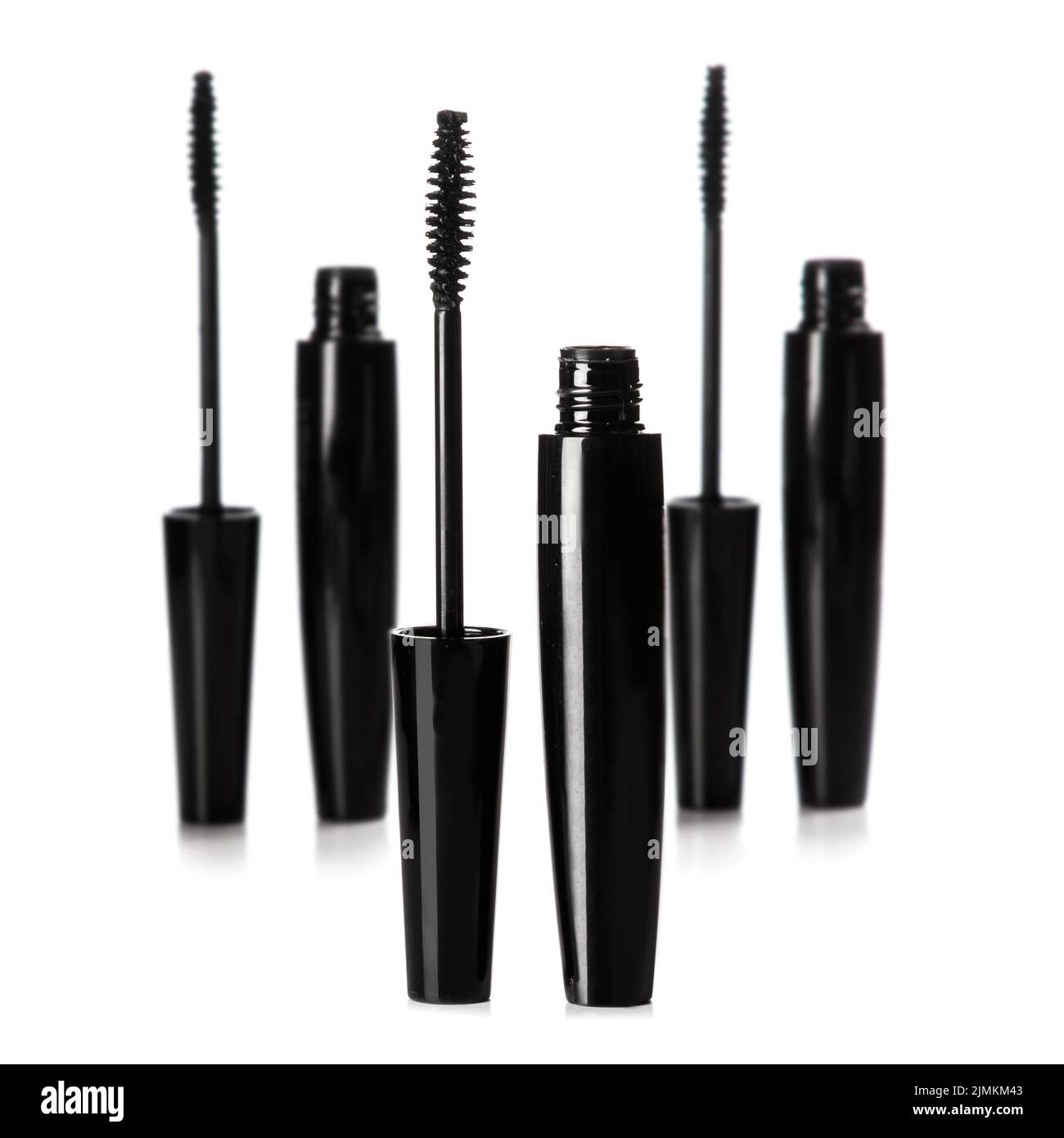Black mascara brushes and containers on white background Stock Photo