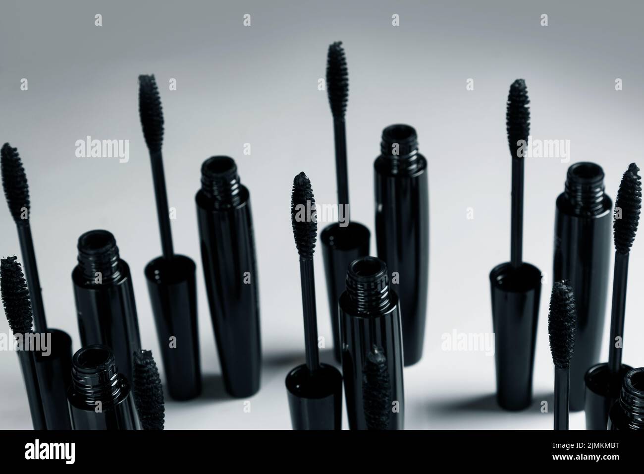 Black mascara brushes and containers on gray background Stock Photo