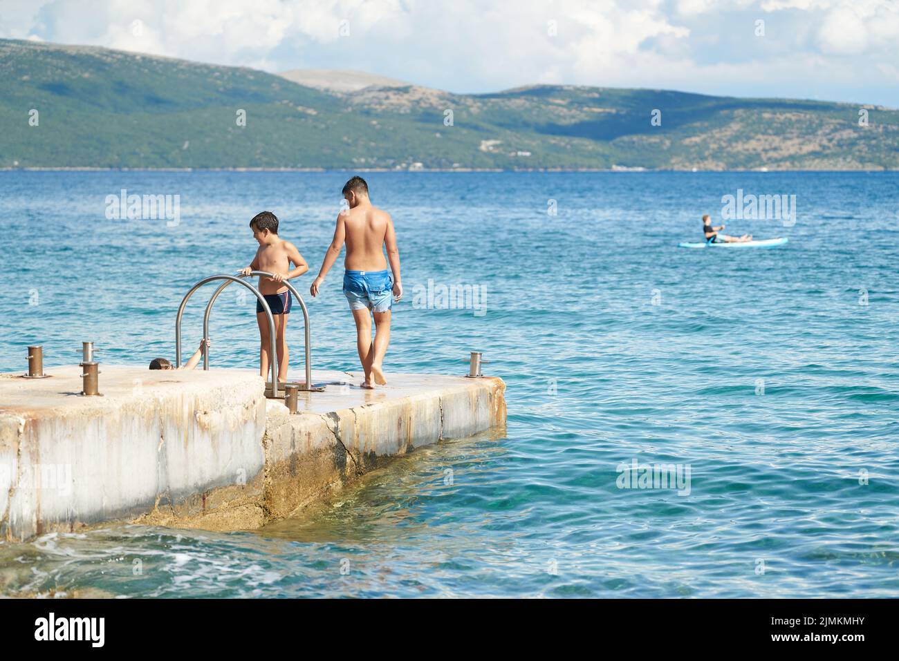 Children on the coast near the town of Krk in Croatia have fun swimming in the Adriatic Sea Stock Photo