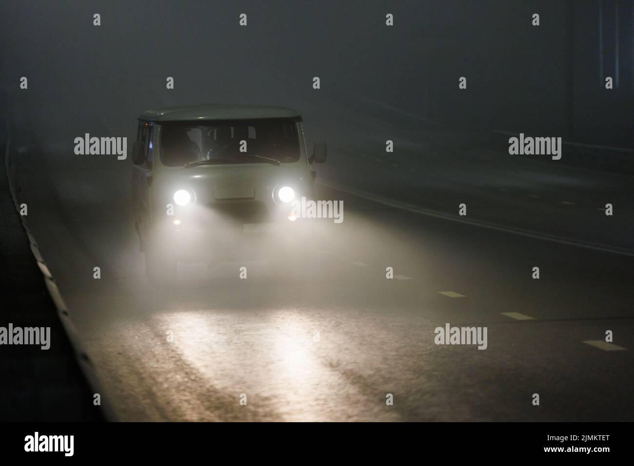 small soviet minivan car moving on night foggy road Stock Photo