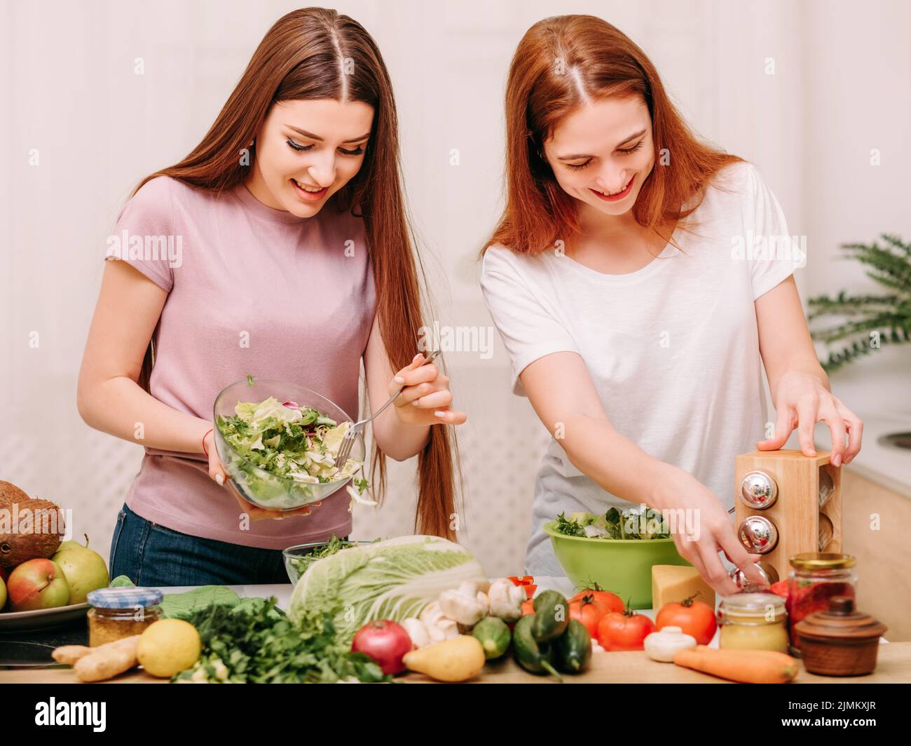 family unity cooking leisure sisters salad kitchen Stock Photo