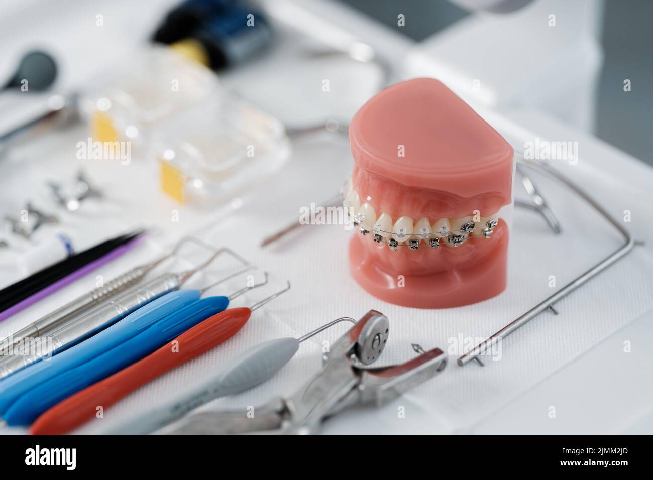 Tooth model with metal braces lying on a dental table with instruments