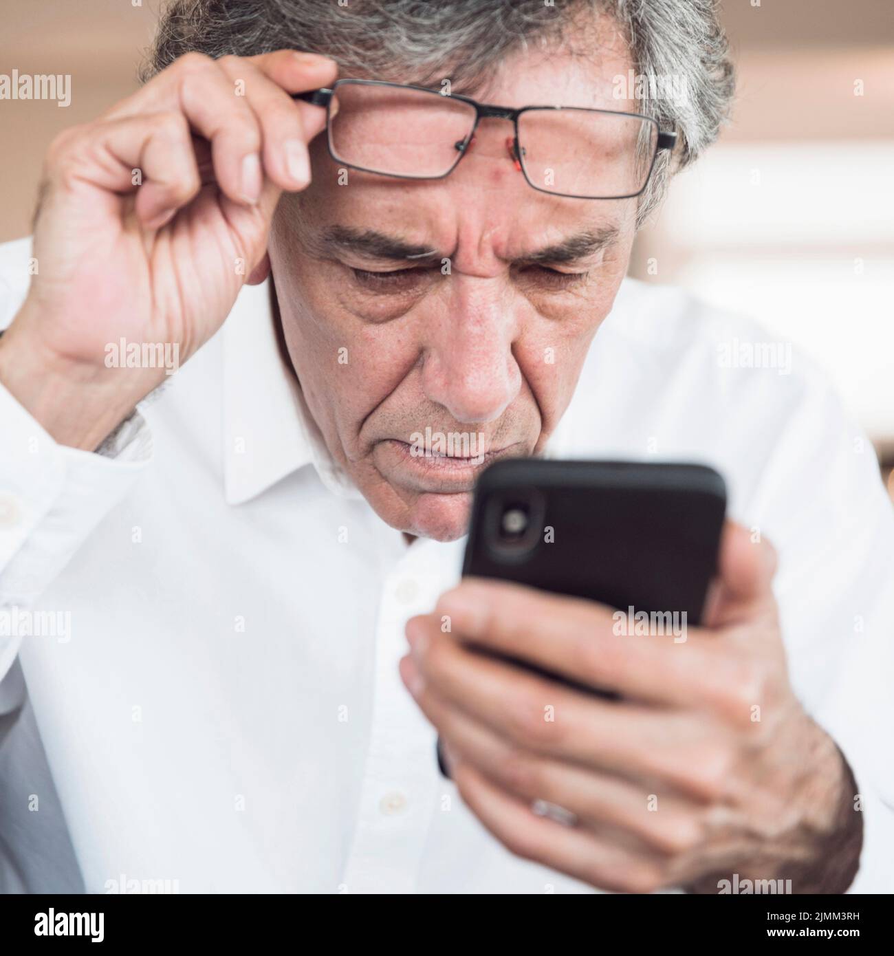Close up serious senior man looking smart phone Stock Photo