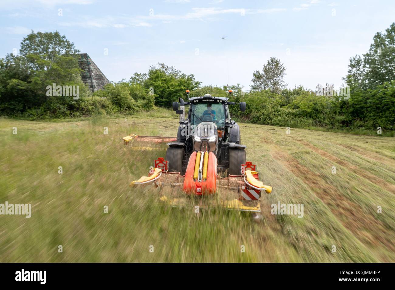 A tractor cutting grass with speed Stock Photo