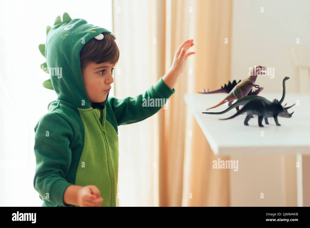 Kid playing with toy dinosaurs Stock Photo