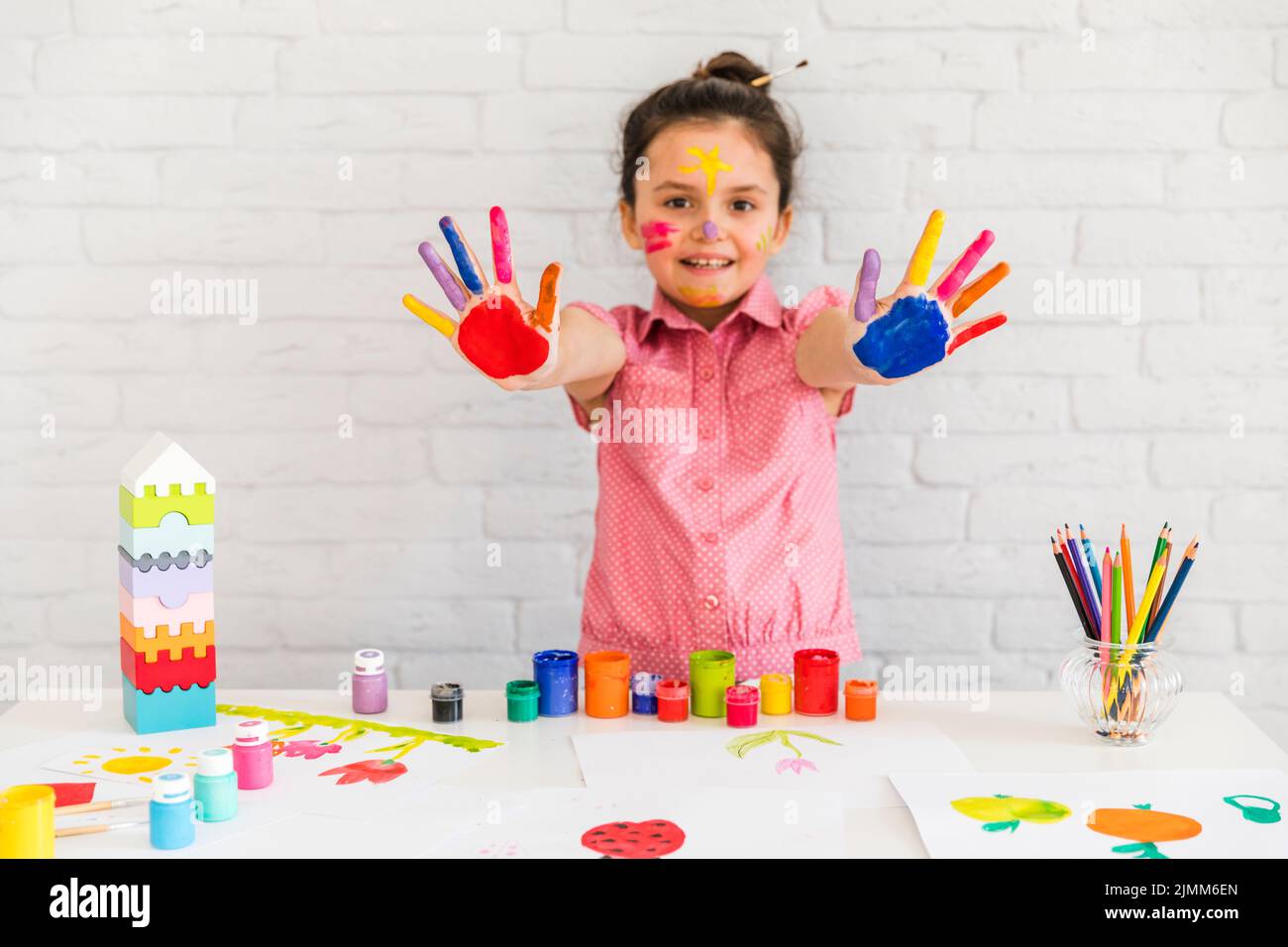 Smiling portrait girl showing her painted colorful hand camera Stock Photo