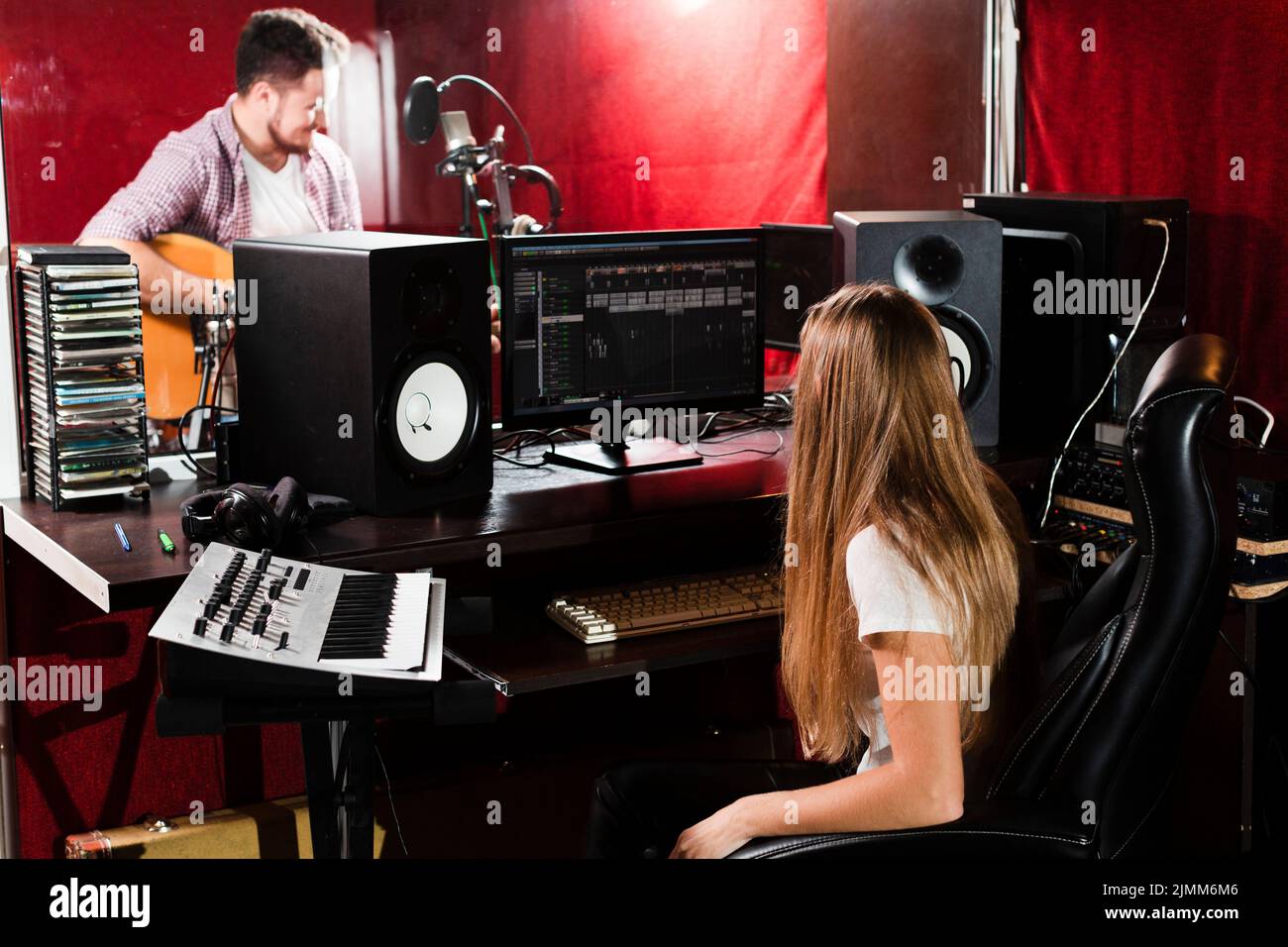 Woman records guitar guy playing studio Stock Photo