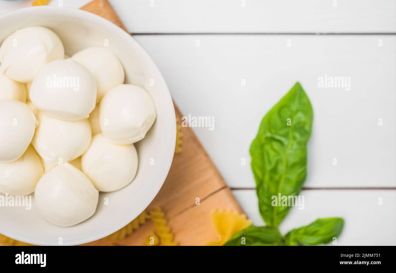 Traditional italian mozzarella cheese bowl with basil leaves Stock