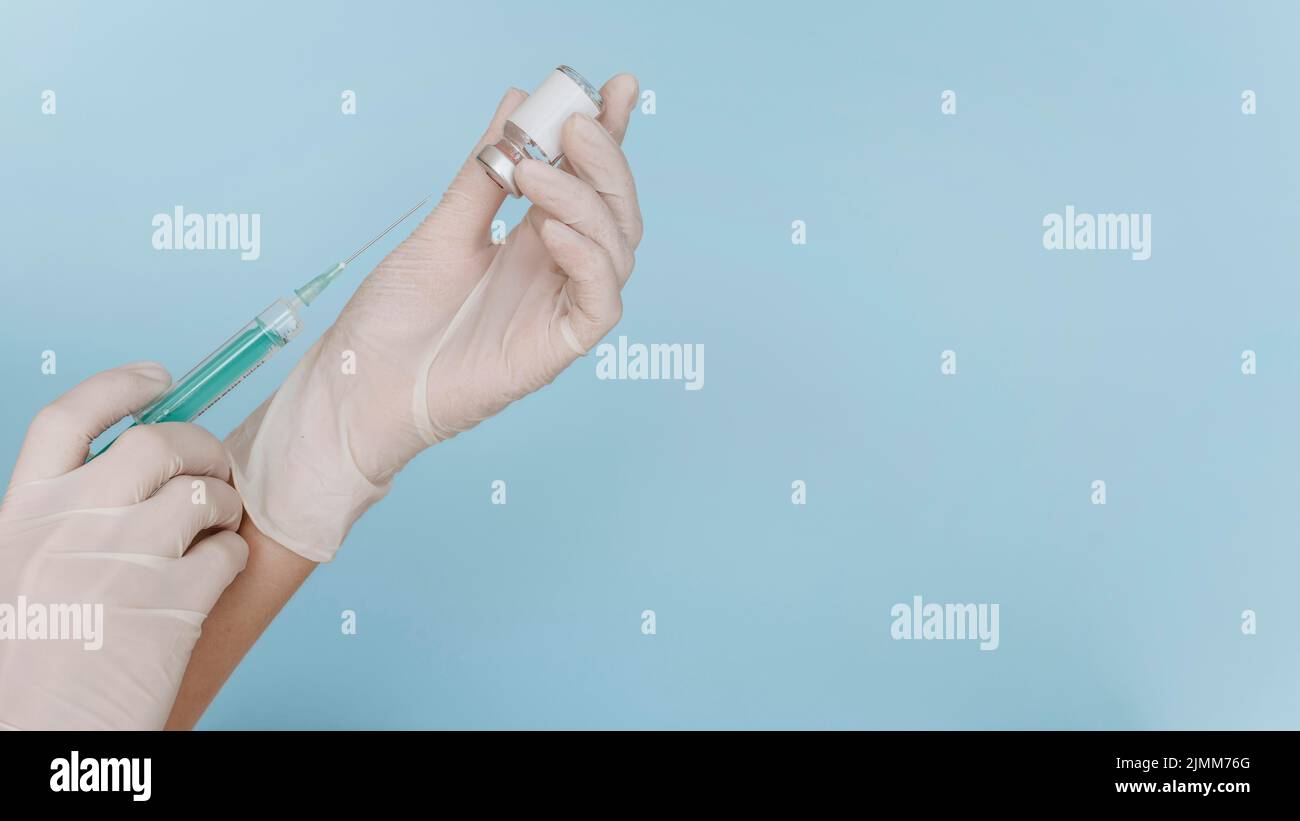 Hand with gloves holding syringe with vaccine copy space Stock Photo