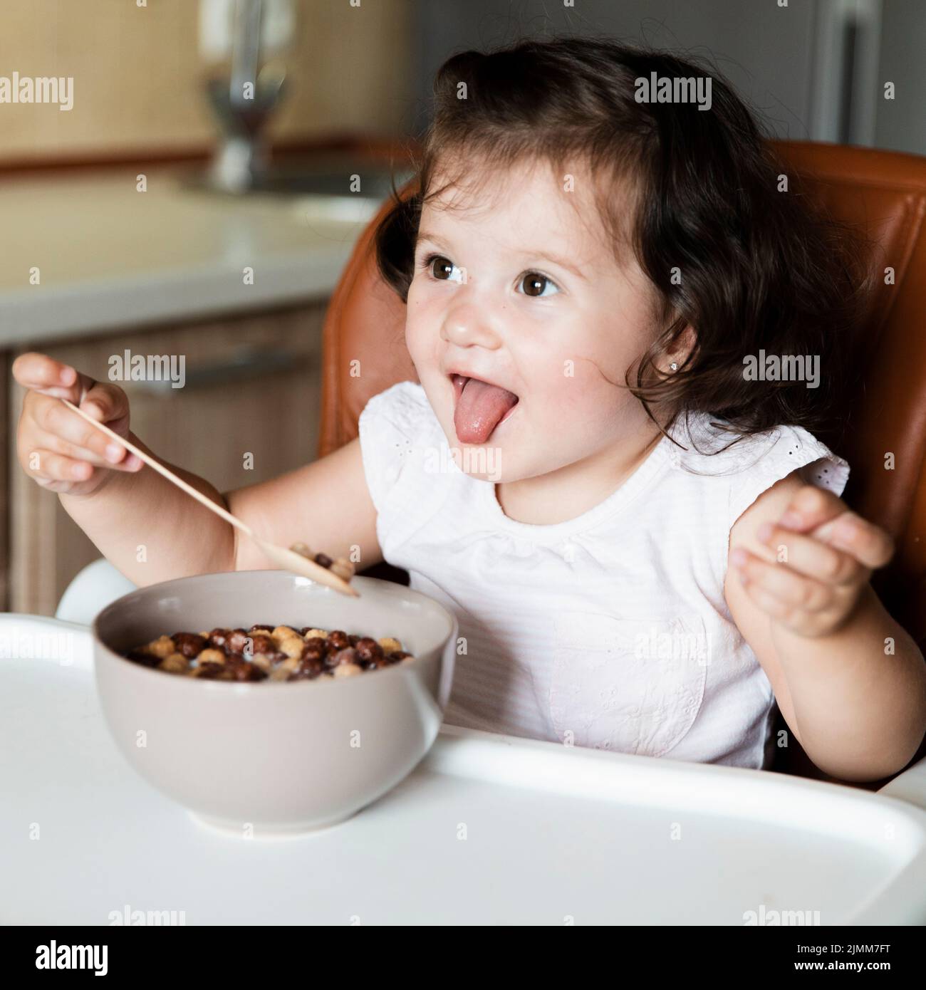 Adorable young girl eating cereals Stock Photo - Alamy