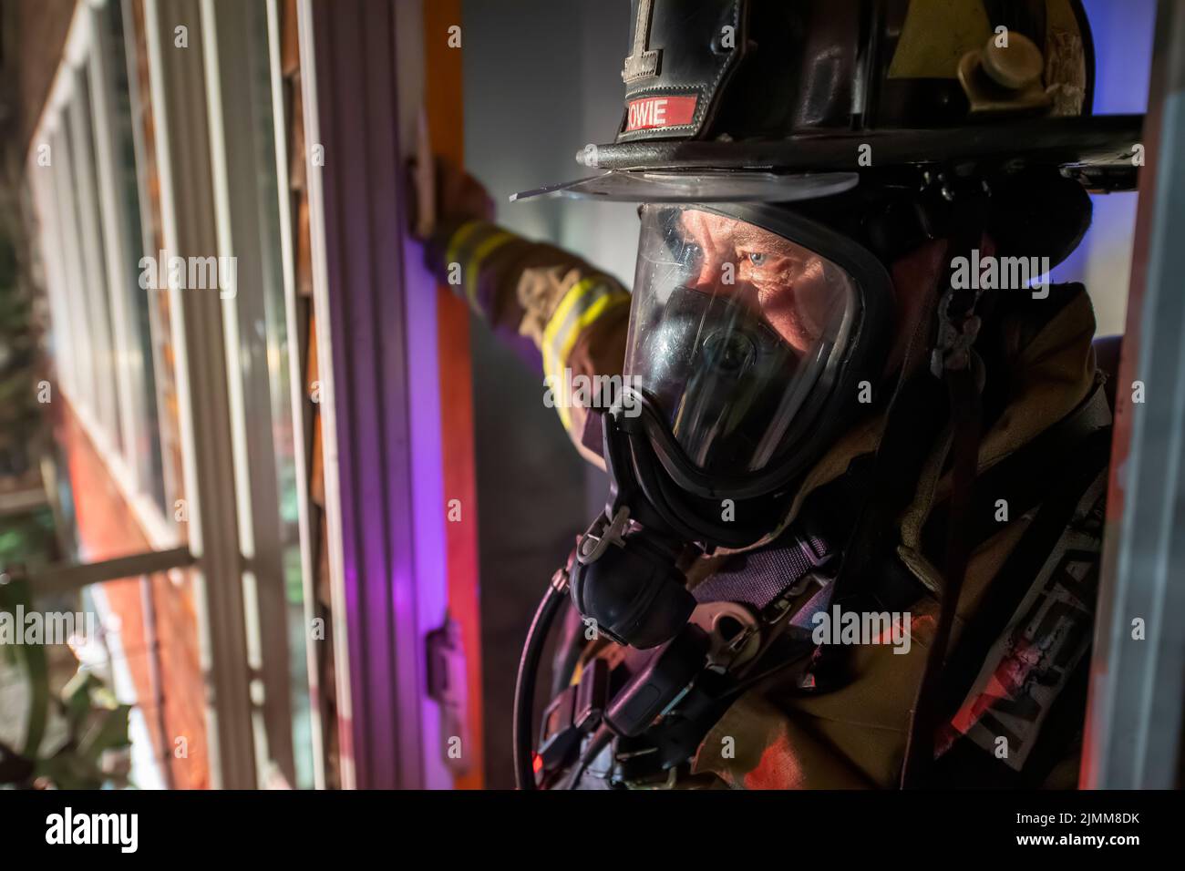 Firefighter Kent Howie wears breathing apparatus as he looks out from the doorway of the building as the East Hampton, Springs and Montauk Fire Depart Stock Photo