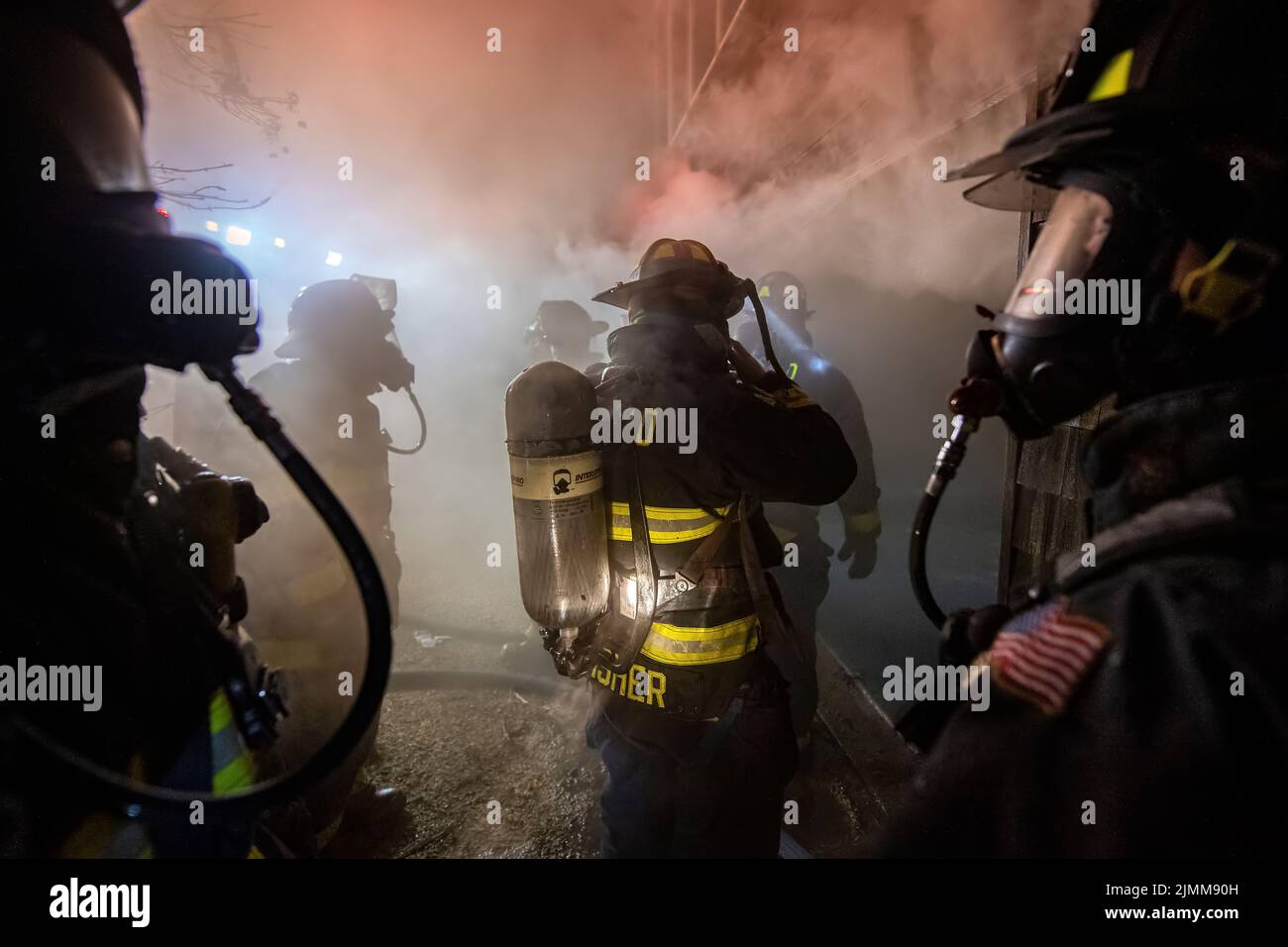 Firefighters wearing breathing apparatus prepare to enter the building as the East Hampton, Springs and Montauk Fire Departments joined the Amagansett Stock Photo